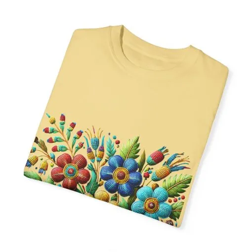 Colorful floral t-shirt with artistic flower print, vibrant unisex garment-dyed tee, bohemian botanical design t-shirt, handmade style floral print tee on light blue fabric.