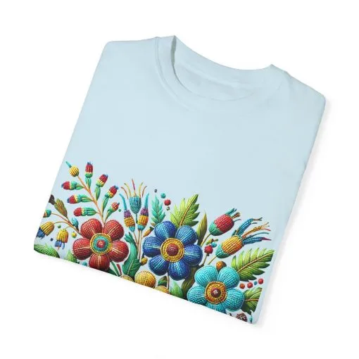 Colorful floral t-shirt with artistic flower print, vibrant unisex garment-dyed tee, bohemian botanical design t-shirt, handmade style floral print tee on light blue fabric.