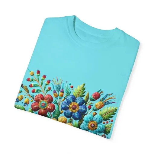 Colorful floral t-shirt with artistic flower print, vibrant unisex garment-dyed tee, bohemian botanical design t-shirt, handmade style floral print tee on light blue fabric.